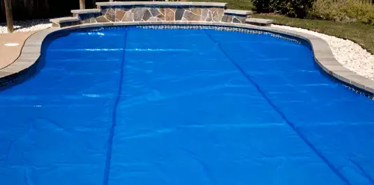 Bâche à bulles utilisée comme couverture d’été sur une piscine